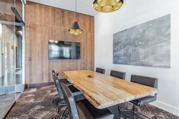 A conference room with a wooden table and black chairs